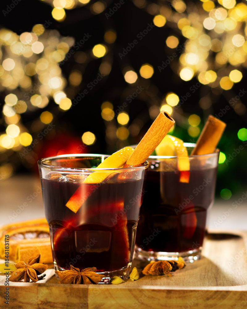Φωτογραφία two glasses with mulled wine on a wooden board, the lights of the garland in the