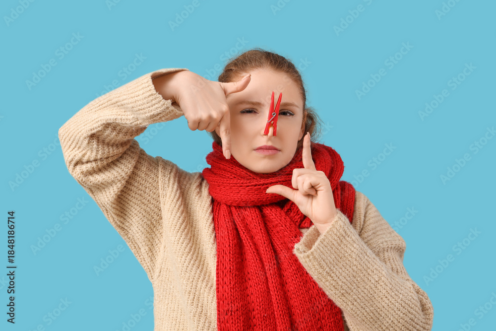 Ταπετσαρία Ill young woman with clothespin on her nose against blue background