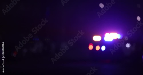 Abstracted illuminated night view of police units on a city street.