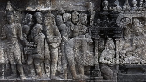 Close-up of gorgeous reliefs narrating Buddhist scriptures and adorning stone facades of Borobudur temple, Magelang, Central Java, Indonesia. World Heritage Site in details. Camera slowly zooms out.