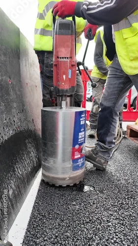 Andover Hampshire England UK. 01.12.2025. Video.  Boring a hole on new asphalt car park surface to form a circular hole for a security post to fit into.
