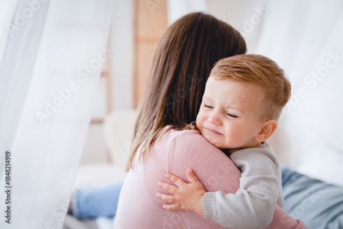 Foto Caucasian mother lulling cradling her crying little small son daughter toddler infant newborn baby