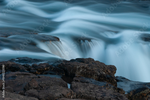 A small river flowing over rocks and stones, in Iceland