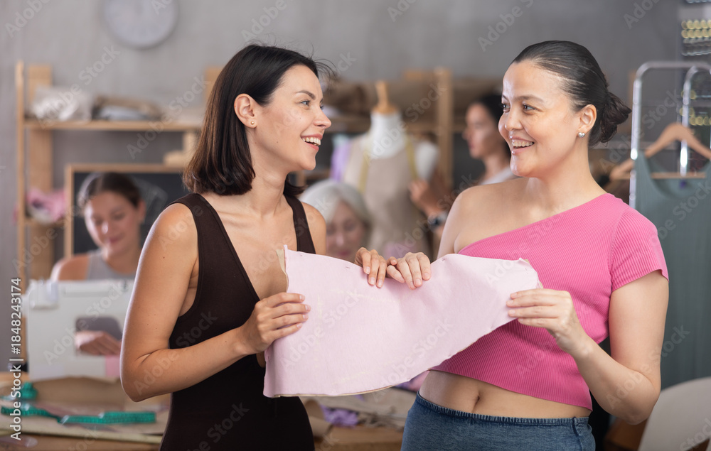 © JackF - Two young women discussing sewn pattern during sewing master class