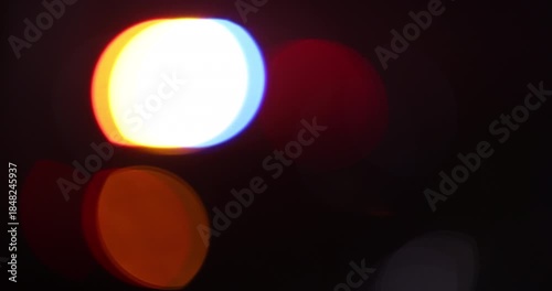 Abstracted illuminated night view of police units on a city street.