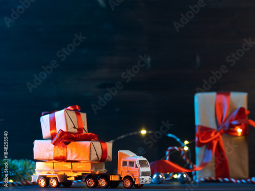 A toy Christmas truck is transporting gift boxes. Copy space
