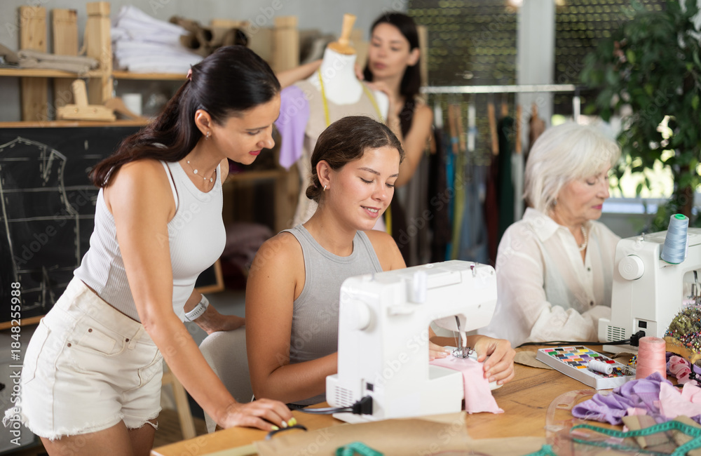Obraz premium Group of women of different ages sew and work with mannequin during sewing master class