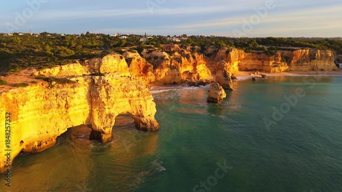 Marinha Beach, Arch, Sea Stacks, Cliffs and Atlantic Ocean on Sunny Morning. Golden Hour. Drone Shot. Algarve, Portugal. Orbiting