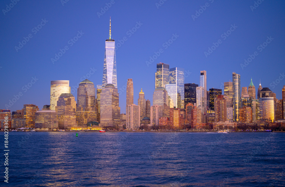 Obraz premium Manhattan skyline glowing at dusk. NYC skyline with downtown towers. New York City skyline as a travel destination. Manhattan skyscrapers forming the city horizon. NYC skyline panorama.