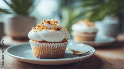 Delicate cream cupcakes with sprinkle topping served on a light blue plate