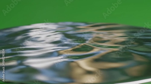 Reflections in still pond water at dawn with minimal reflective surface forming a effect ad_ready green screen subtle reflection