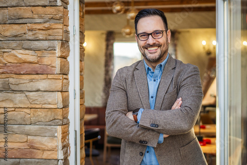 Foto Smiling business owner welcoming customers inside his restaurant entrance