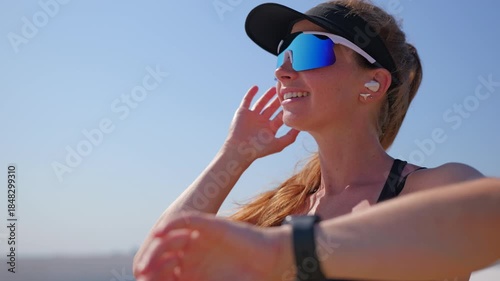 Woman smiles while checking her watch during a run