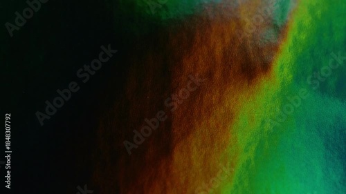 Shiny lacquered wallpaper with iridescent colors.iridescent multicolored background.shiny surface with highlights of color in blue, green, orange tones. 4k footage
