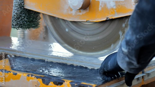 Tile cutting.A man in a black construction suit cuts deck tiles. Mechanical tile cutting machine in operation. 4k footage