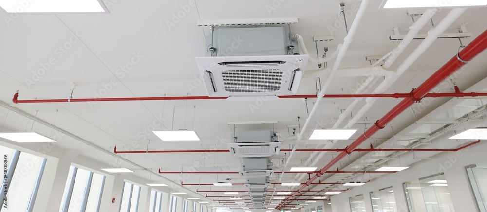 Obraz premium Industrial Architectural Design: HVAC Systems, LED Lights, and Fire Sprinklers on Concrete Ceiling.