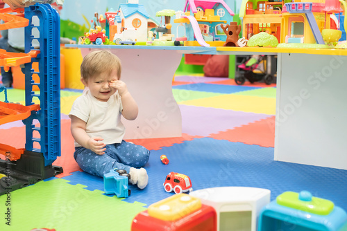 Bilde på lerret little boy crying in play center or kindergarten, child sitting alone on the floor among toys