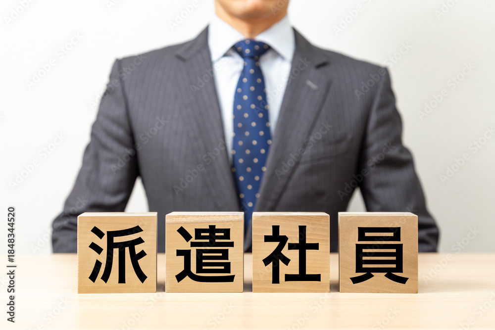 Obraz premium 「派遣社員」と書かれたブロックとビジネスマン