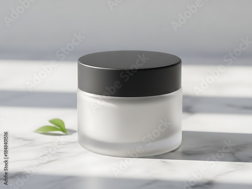 A frosted glass jar with a black lid, featuring a small green leaf and sunlight casting shadows on a marble surface