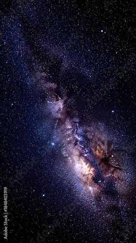 The colorful galactic core of the Milky Way cuts diagonally through a black, starry sky