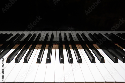Close-up of piano keys with dramatic lighting and shadow contrast.