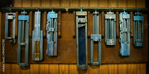Φωτογραφία Set of vintage metal type composing sticks hang on the wall of a letterpress wor