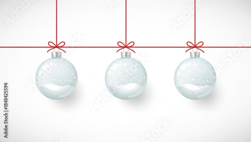 Three transparent blue christmas ornaments hanging from red strings with bows on a white background with snowflakes