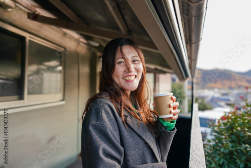 A smiling woman holding a cup of coffee