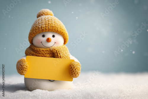 Charming miniature snowman presenting a blank yellow card for holiday messaging