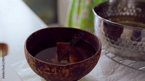 Melted Wax Flowing from Pitcher into Coconut Shell Bowl in Close Up Overhead Angle as Candle Pouring Continues, Handmade Craft Concept