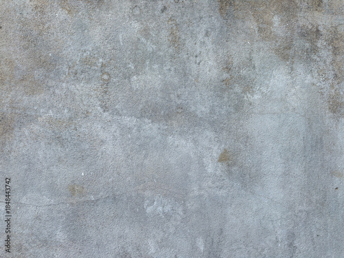 A weathered gray concrete wall background with a rough grunge texture and aged cement surface creates a vintage grungy stone backdrop material