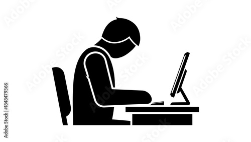 Silhouette of person working at desk on computer