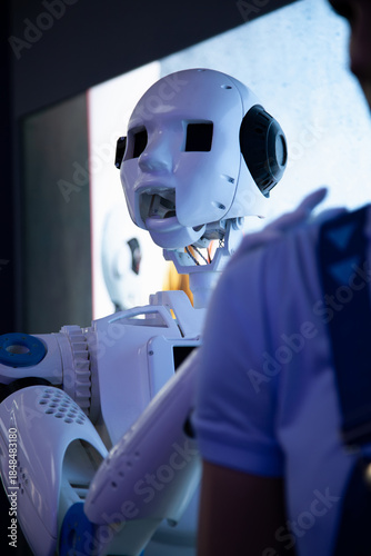 white humanoid robot helps a person at work