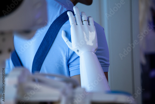 robotic arm on the shoulder of a working person