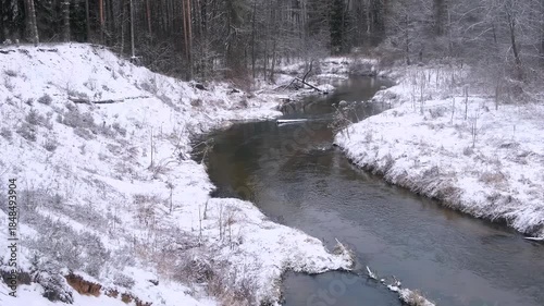 winding forest river by winter; tilt camera movement

