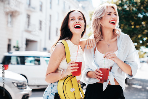 Canvas Print Two young beautiful smiling glam female in trendy summer clothes