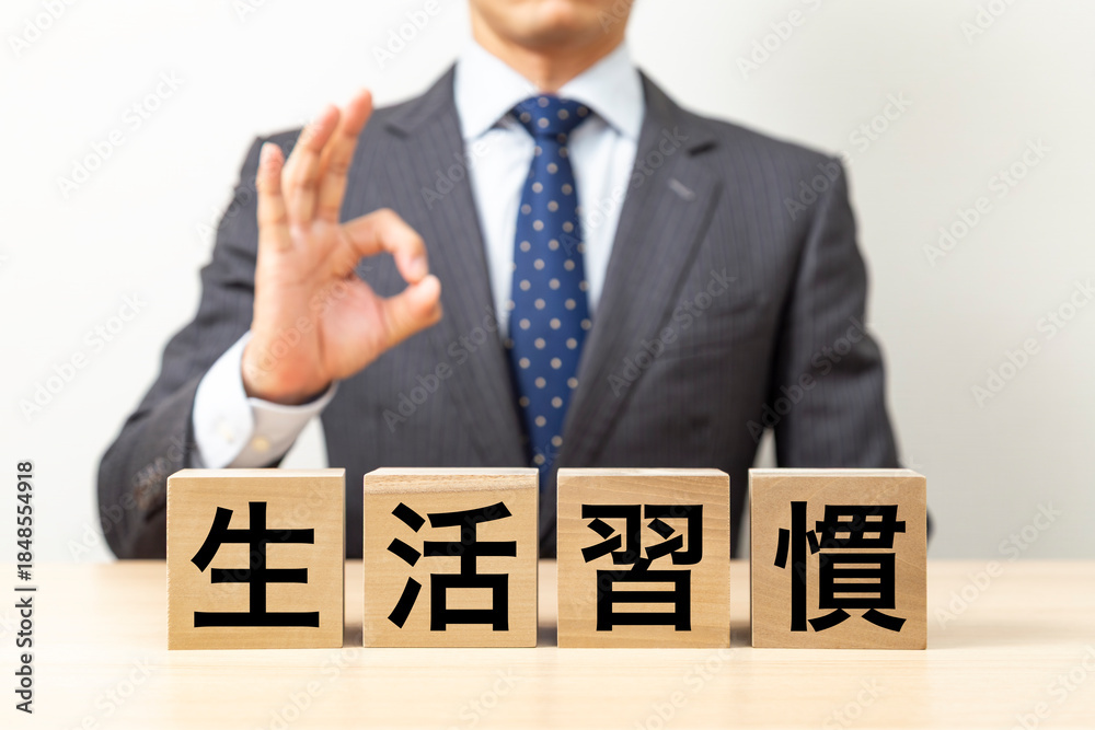 Obraz premium 「生活習慣」と書かれたブロックとOKポーズをするビジネスマン