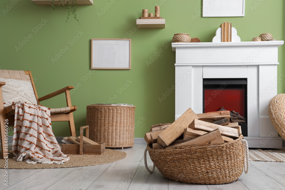 Fototapeta premium Interior of living room with armchair, wicker coffee table and firewood near fireplace