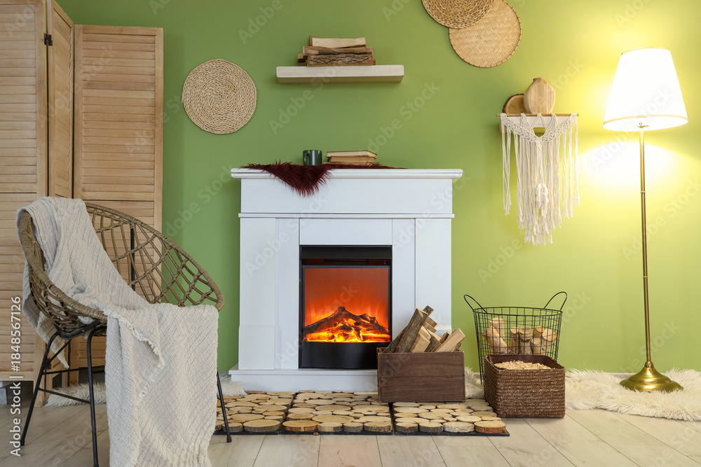 Fototapeta premium Interior of living room with armchair, folding screen, lamp and firewood near fireplace