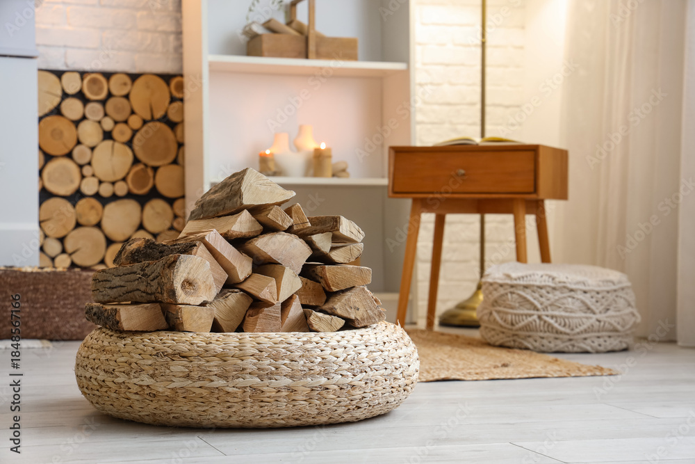 Fototapeta premium Interior of living room with shelving unit, wicker ottoman and firewood
