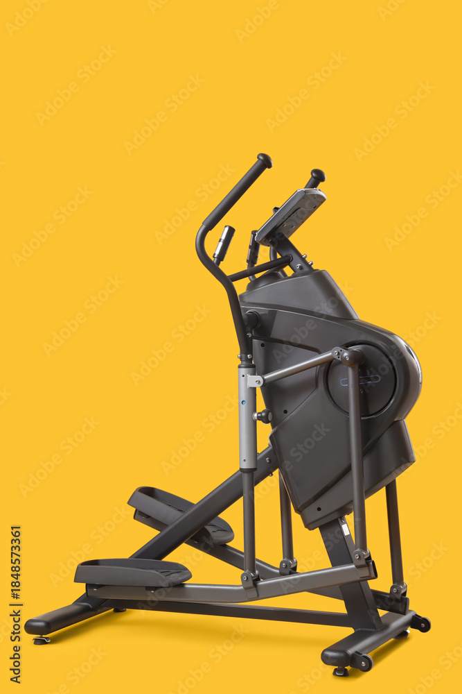 Fototapeta premium Modern elliptical machine on yellow background