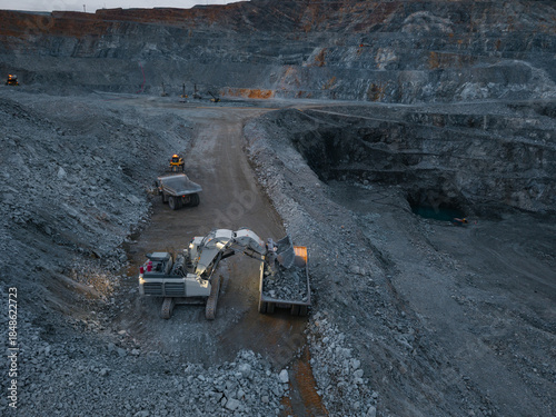 Fotografi Aerial view Excavation and mining truck transport at large open pit mine at dusk