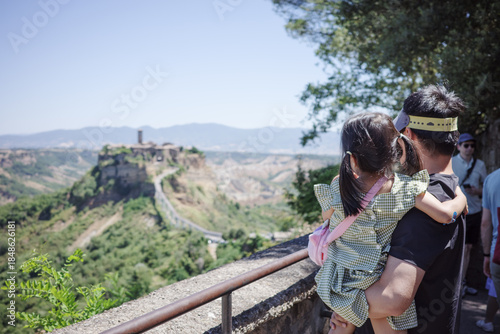 фотографія Father Holding Young Child Overlooking Mountain Valley and Historic Town, Family