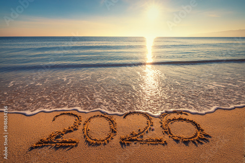 Fototapeta Naklejka Na Ścianę i Meble -  Happy New Year 2026 concept, lettering on the beach. Written text on the sea beach at sunrise.