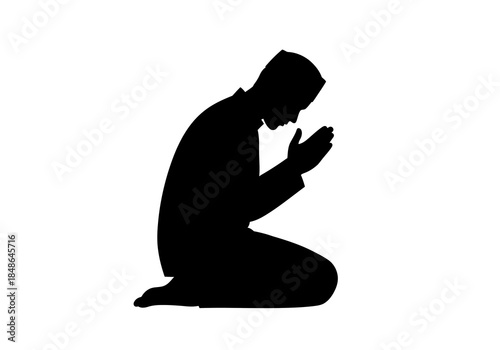 Silhouette of a Muslim Man Praying Kneeling Down.