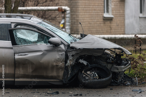 Fotografija The aftermath of a severe accident: a gray SUV with catastrophic damage to the front end after a collision on a city street