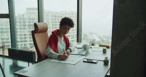 Professional studying technical drawings with cityscape backdrop