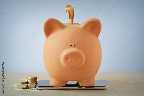 Piggy bank with money on mobile phone - Concept of savings and trading online