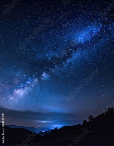 Stunning view of the Milky Way galaxy arching over dark mountain silhouettes at night.