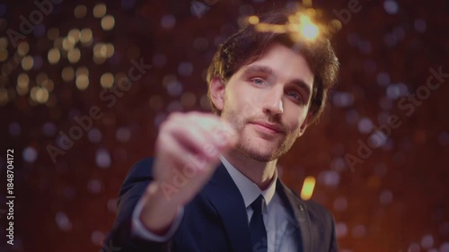 Handsome european man in suit holding sparkler light, enjoying a party or Christmas. Caucasian male burns Bengal fire, smiling and looking on camera. Special occasion and festive mood. Celebrating